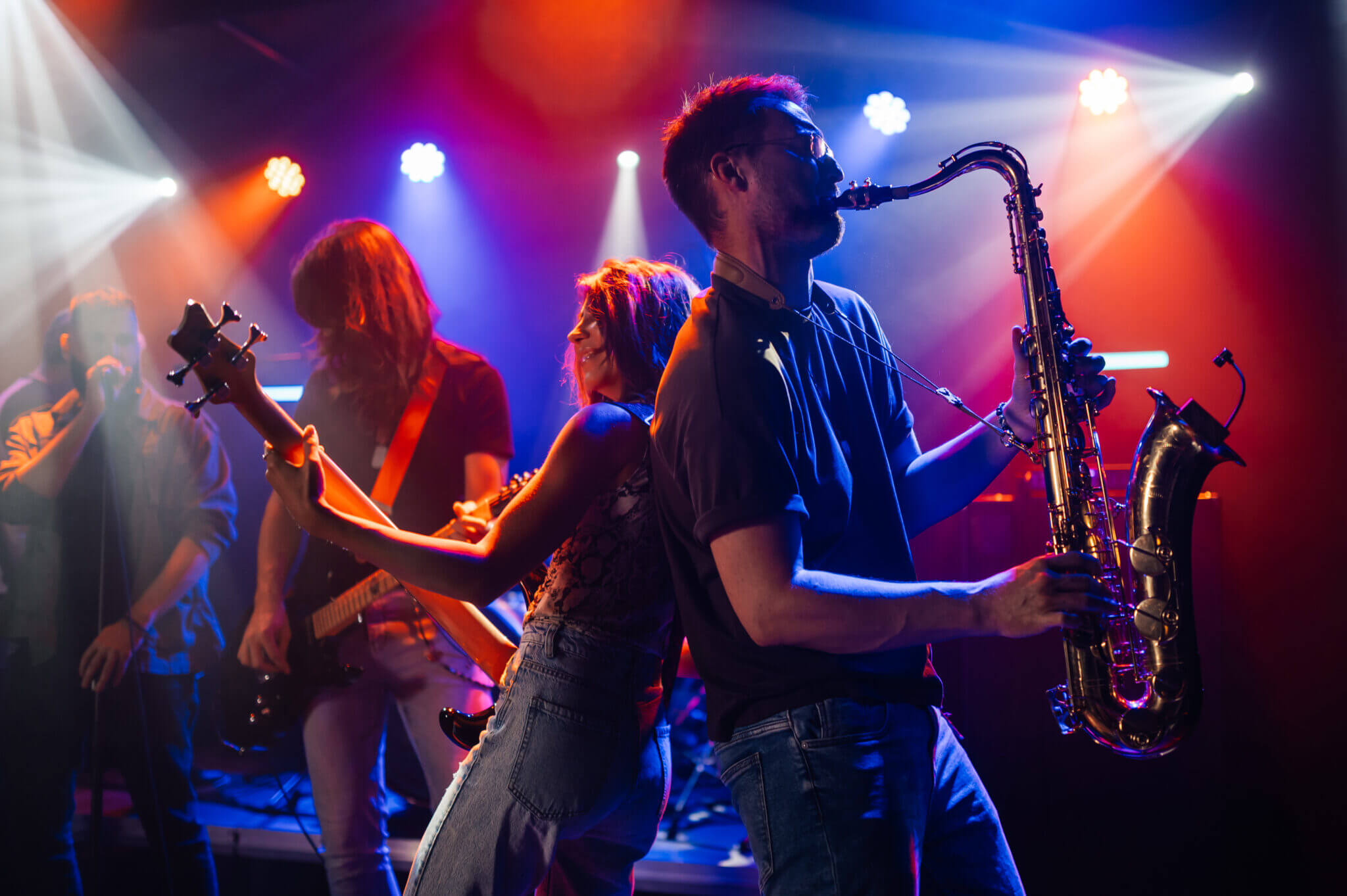 Band spielt leidenschaftlich auf einer Bühne mit farbigem Licht.